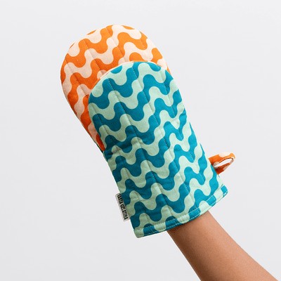 Vattert grytevott i bomull med bølgemønster og to farger. En leken klassiker på kjøkkenet – både dekorativ og varmebestandig.